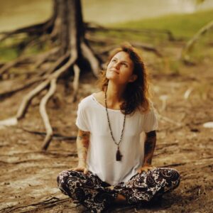 a woman sitting on the ground with her eyes closed
